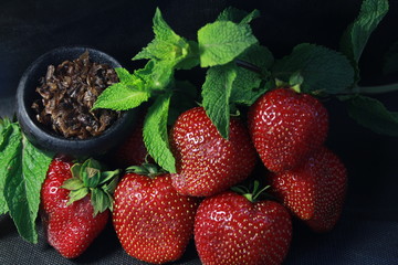 bowl with tobacco for hookah. fruits on a black background. smoke hookah