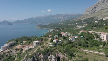 Drone flies above the coastline of the Adriatic sea, southern Montenegro, in a sunny summer day. Water in the sea is turquoise, clean and clear
