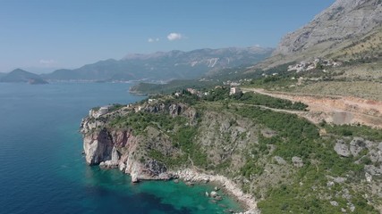 Drone flies above the coastline of the Adriatic sea, southern Montenegro, in a sunny summer day. Water in the sea is turquoise, clean and clear