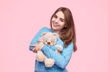 Cheerful teenager hugging teddy bear