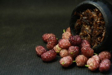 bowl with tobacco for hookah. fruits and berries on a black background. smoke hookah