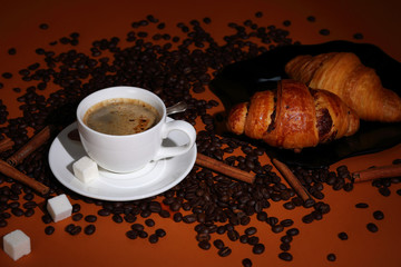 Coffee still life with croissants and cinnamon