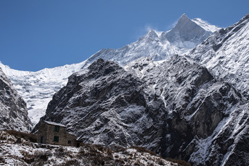 machapuchare peak in himalayas annapurna base camp trekking route with brick house