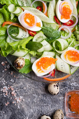 fresh  gourmet salad with  red  salmon caviar and  eggs and vegetables. close up.  Protein luxury delicacy  healthy food. beautifull served. flat lay