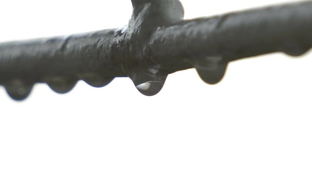 Closeup of rain drop hanging on metal fence and swing on wind, concept of loneliness, depression