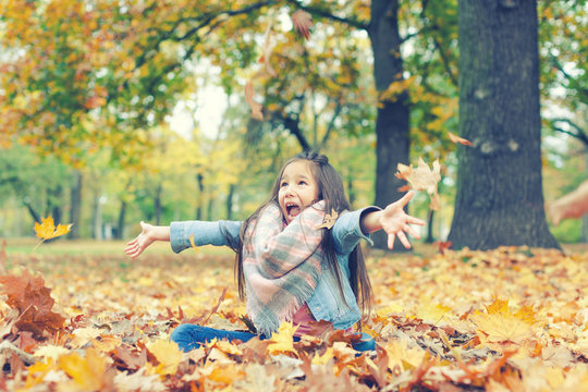Mädchen im Herbst wirft bunte Ahornblätter in die Luft Natur 