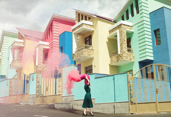 Woman with pipe spraying pink powder paint on head