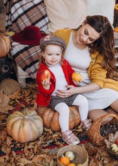 Beautiful baby girl in autumn garden with mother