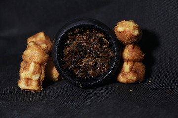 bowl with tobacco for hookah. fruits and berries on a black background. smoke hookah