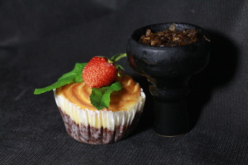 bowl with tobacco for hookah. berries on a black background