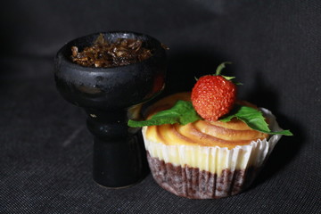bowl with tobacco for hookah. berries on a black background