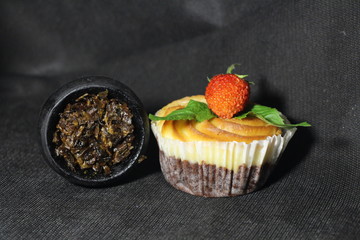 bowl with tobacco for hookah. fruits and berries on a black background. smoke hookah