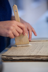 a lady's hand cleaning an old book