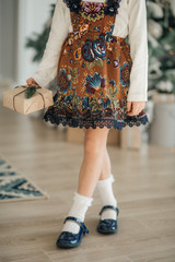 Beautiful baby girl near a Christmas tree with gifts