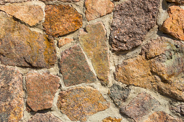 Stone fence texture of decorative masonry with large stones and boulders for an art background.