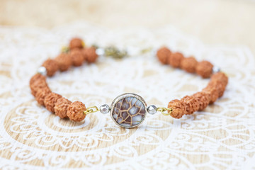 Mother pearl natural bead rudraksha seed bracelet on decorative background