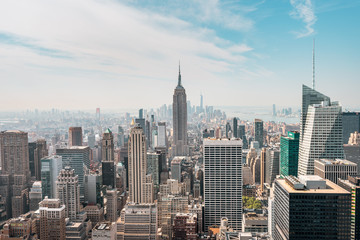 New York City Manhattan, NYC/ USA - 08. 21. 2017: Top of the Rock Panoramablick über die Skyline vom Rockefeller Center nach New York und das Empire State Building an einem leicht bewölkten sonnigen Tag mit blauem Himmel