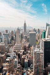 Fototapeta premium New York City Manhattan, NYC / Usa - 08 21 2017: Top of the Rock panorama na panoramę z centrum Rockefeller do Nowego Jorku i Empire State Building w lekki pochmurny, słoneczny dzień z błękitnym niebem