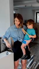 mother with screwdriver and a child are instaling a furniture