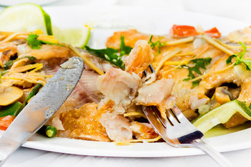 Pieces of Pomfret fish on a fork close-up.