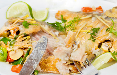 Pieces of Pomfret fish on a fork close-up.