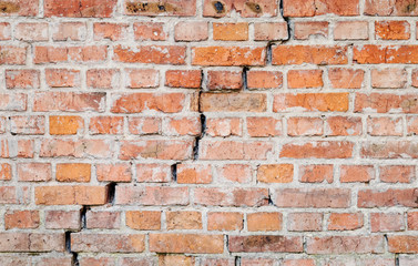 Texture of old weathered brick wall with long crack.
