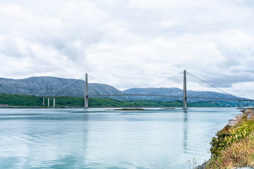 Panoramic sideview photo of Helgelandsbrua (norwegian) or Helgeland Bridge is Norway's finest bridges between Alstahaug and Leirfjord at Helgeland, Norway. Cloudy and quiet summer weather