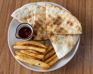 French fries and quesadilla on plate