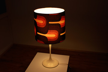 a vintage midcentury lamp from the 60s with a large brown lampshade standing on a cocktail table in...