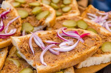 Slices of bread with lard greaves and onion topping