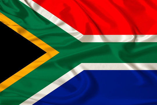 beautiful photo of the national flag of South Africa on delicate shiny silk with soft draperies, the concept of state power, country life, horizontal, close-up, copy space