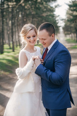 Bride and Groom at wedding Day walking Outdoors on spring nature. Bridal couple, Happy Newlywed woman and man embracing in green park. Loving wedding couple outdoor. 