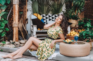 Portrait of a beautiful young woman in a summer gazebos with fruits