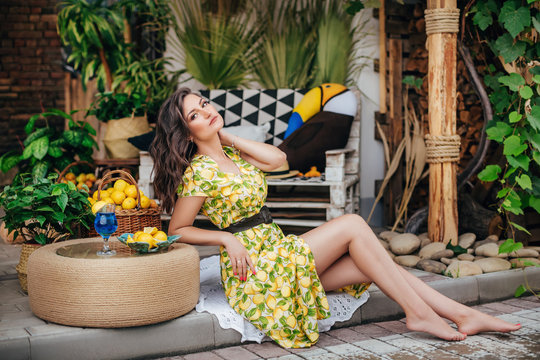 Portrait of a beautiful young woman in a summer gazebos with fruits