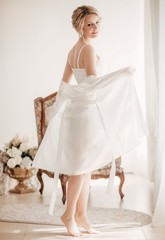 Fototapeta na wymiar Beautiful blonde bride with stylish make-up in white dress.Morning bride