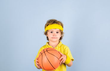 Cute little basketball player training. Children and sport. Little basketball player in sportswear holds ball. Small boy in sport uniform playing basketball. Sport equipment. Boy with basketball ball.
