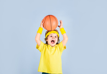 Little basketball player in sportswear trows ball. Small boy in sport uniform playing basketball. Sport equipment. Boy with basketball ball. Cute little basketball player training. Children and sport.