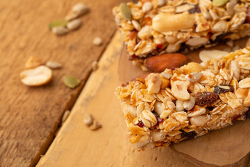 granola bars and nuts on a wooden background with space for design, horizontal photo, diet, proper nutrition