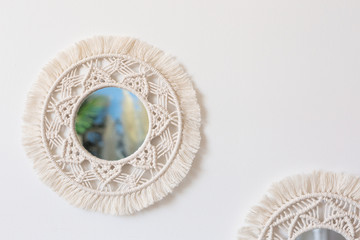Two woven macrame mirrors on a white wall