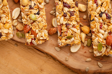 granola bars and nuts on a wooden background with space for design, horizontal photo, diet, proper nutrition