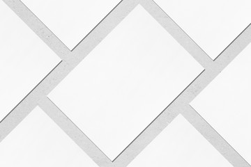 Close up of empty white rectangle poster mockups lying diagonally with soft shadow on neutral light...