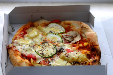 Small vegetarian pizza in a box. Take away food. Selective focus.