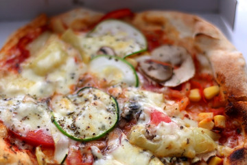 Small vegetarian pizza in a box. Take away food. Selective focus.