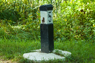 railway post on a background of green nature