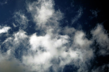 White fluffy clouds on a dark background