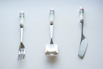 cutlery dessertware fork spoon knife on a white background with a rose on the handle