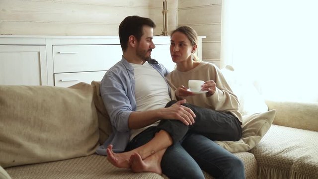 Couple in love sitting together on couch talking planning day