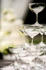 Pyramid of glasses of champagne at outdoor garden in wedding ceremony