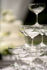 Pyramid of glasses of champagne at outdoor garden in wedding ceremony