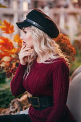 Beautiful woman in autumn garden with yellow and red leaves